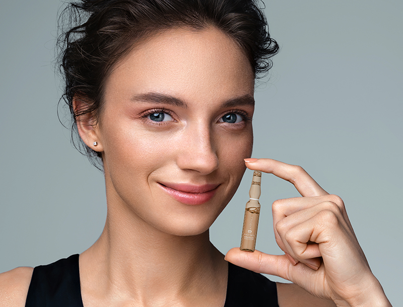 Frau hält eine Ampulle in der Hand.